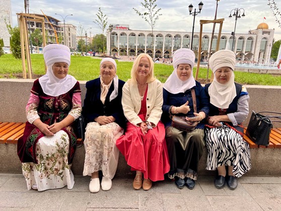 Women wearing traditional Kyrgyz attire—beldemchi (a wrap-around skirt) and chyptama (a fitted vest with roots in nomadic culture)