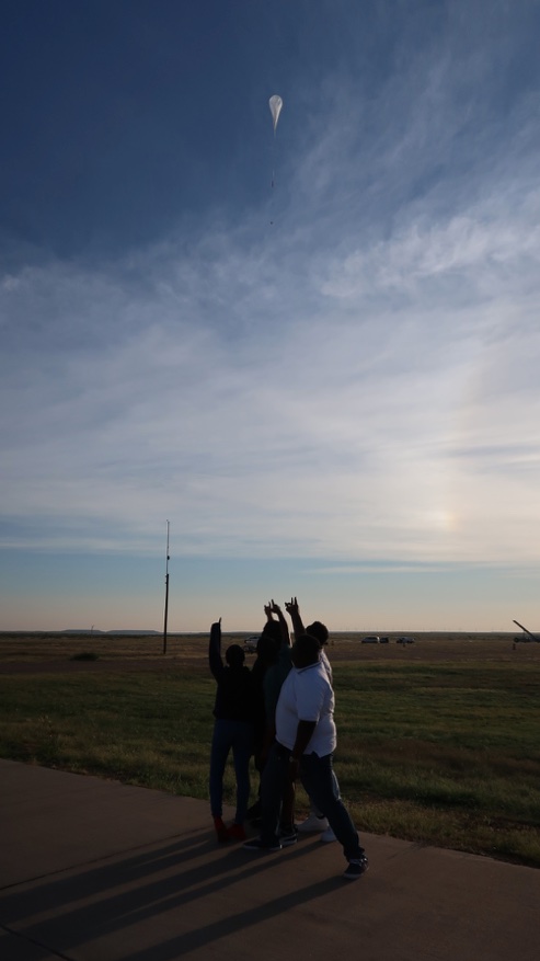 Students and HASP 2022 payload. Students pointing to their payload flying on HASP 2022.